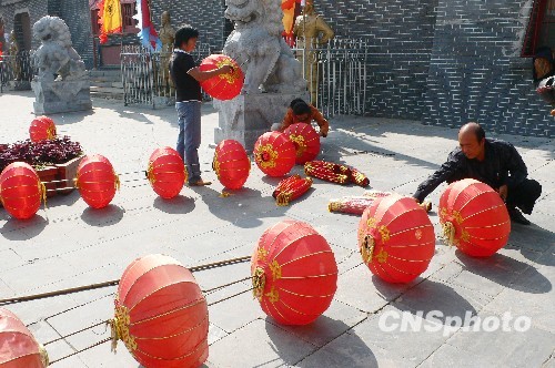 8月31日，河南省開封市天波楊府門口，工作人員在準(zhǔn)備懸掛大紅燈籠。隨著“十一”國慶節(jié)和“十一”旅游黃金周的臨近，古城開封的公園景點(diǎn)已早早開始備戰(zhàn)，營造喜慶祥和的旅游環(huán)境，迎接八方客人。 中新社發(fā) 李俊生 攝