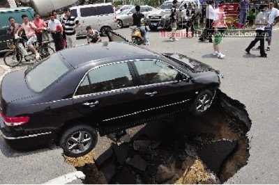 4日，南昌市昌南大道與迎賓北大道交叉口附近路面突然發(fā)生塌陷，一輛過(guò)路小轎車被卡在洞口處。圖/新華社