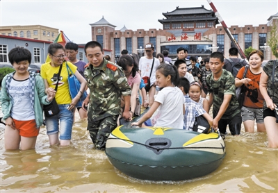 昨日，消防戰(zhàn)士在秦皇島市山海關(guān)火車站涉水運送旅客。當(dāng)日，受持續(xù)強降雨影響，河北省秦皇島市海港區(qū)、山海關(guān)區(qū)等地出現(xiàn)內(nèi)澇，部分列車停運。 新華社發(fā)