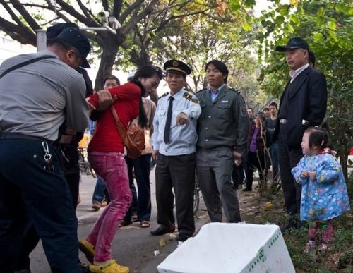 城管與女小販發(fā)生沖突后，女小販被警方強行帶走，她的孩子在一旁放聲大哭。南都記者 黎湛均 攝